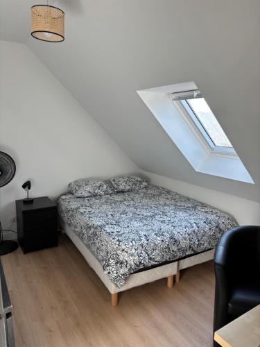 une chambre avec un lit et une fenêtre dans l'établissement Maison bord de mer normandie, à Langrune-sur-Mer