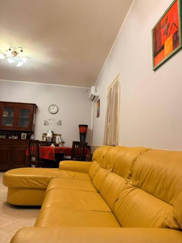 een woonkamer met een gele bank en een tafel bij Casa Julia in Palermo