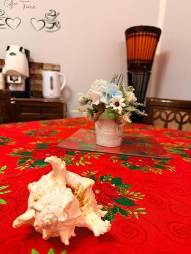 een tafel met een schedel op een rood tafelkleed met bloemen bij Casa Julia in Palermo