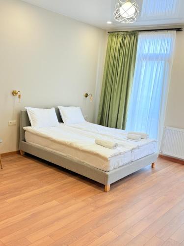 a large bed in a room with a large window at Cosy City-View Flat in Mtatsminda, flat 5 in Itʼkhvisi