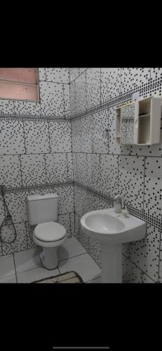 a bathroom with a toilet and a sink at Casa com 3 quarto mobiliada in Manaus