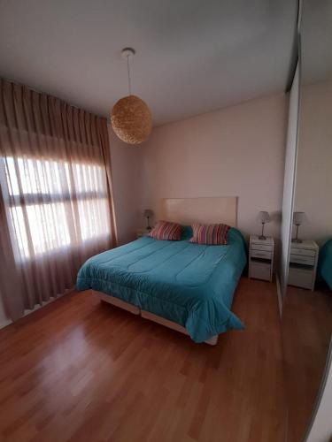 una camera da letto con un letto con una coperta blu di Viejo Lobo de Mar a Puerto Pirámides