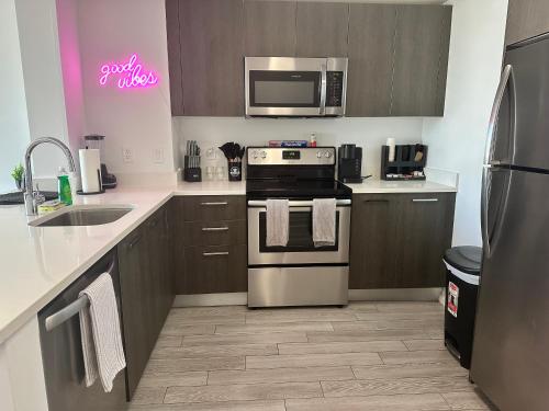 a kitchen with a stove and a microwave at Downtown Miami 2Br 2Bath Oasis Bayside & Port of Miami Minutes Away in Miami