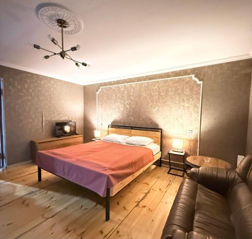 een slaapkamer met een bed en een bank bij Apartment Once in Kazbegi in Kazbegi