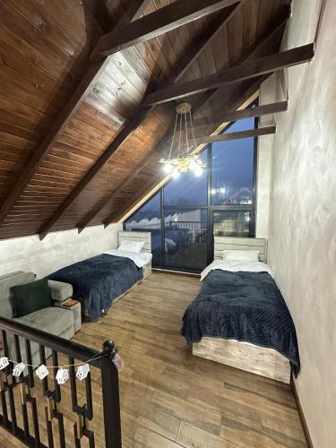 a bedroom with two beds and a large window at Sultan Villas A-Frame in Quba in Quba