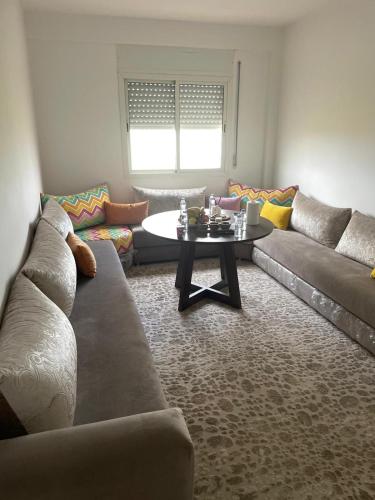 a living room with a couch and a table at Appartement à Skhirat plage in Skhirat