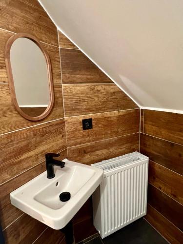 a bathroom with a sink and a mirror and a radiator at Chalupa Bohunka in Kašperské Hory