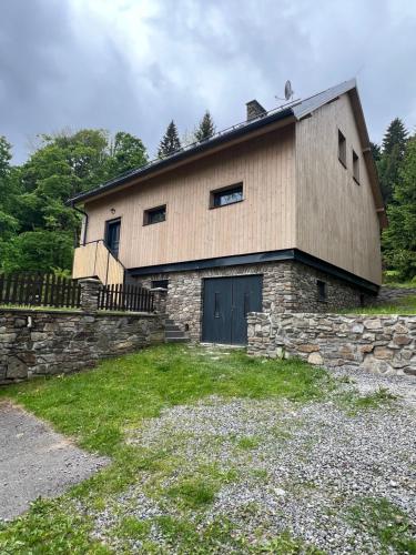 a stone building with a door and a stone wall at Chalupa Bohunka in Kašperské Hory