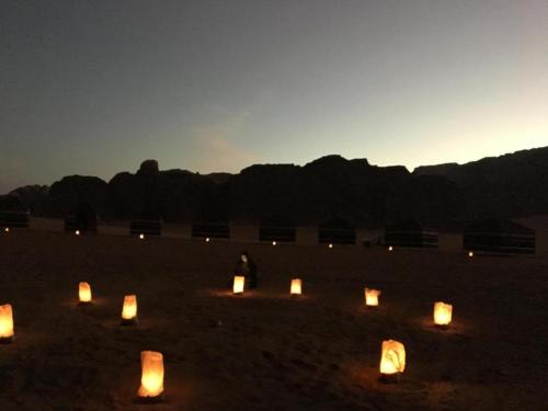 una persona in piedi in un campo con candele nella sabbia di wadi Rum Desert Legends a Wadi Rum