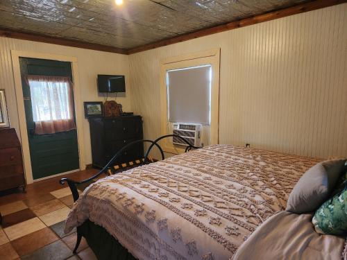 - une chambre avec un lit, une fenêtre et une porte dans l'établissement Bigfoots Bungalow, à Bandera