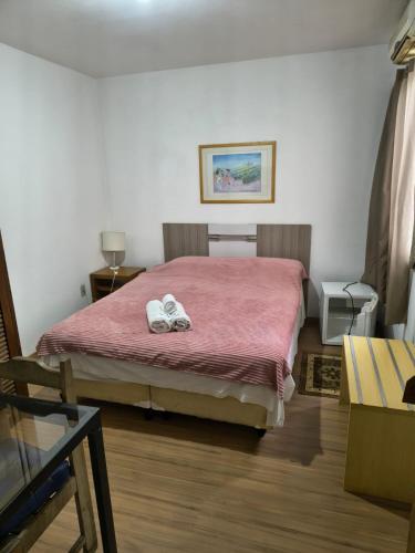 ein Schlafzimmer mit einem Bett, auf dem zwei Handtücher liegen in der Unterkunft Hotel Cassino Bagé in Bagé