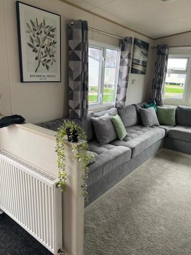 a living room with a gray couch and windows at SummerBreeze Retreat in Hartley