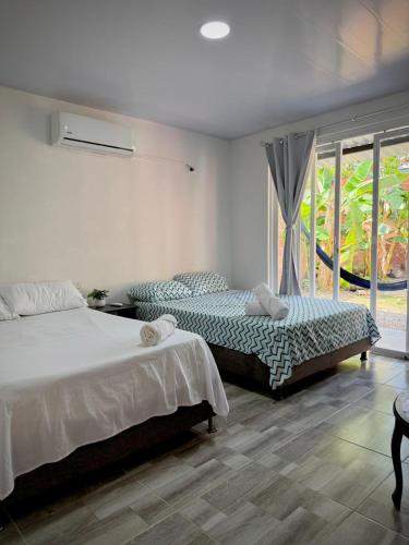una camera da letto con due letti e una finestra di Tu hogar en Tauramena a Tauramena