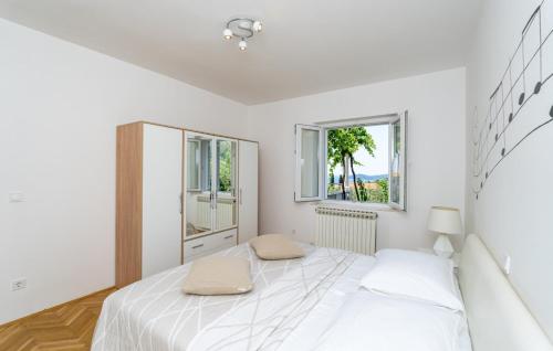 una camera da letto bianca con un letto e due finestre di Villa None Kate by Villas Guide a Dubrovnik