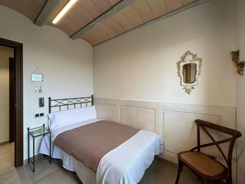 een slaapkamer met een bed en een stoel bij Casa Rural Cal Roseto con jacuzzi in Selvanera