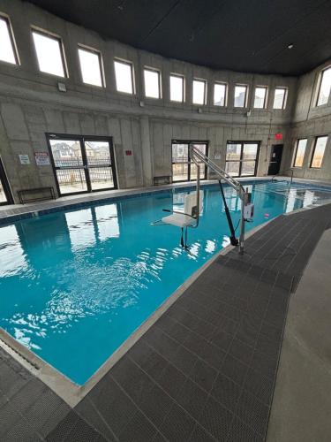 a large pool with blue water in a building at Nice escape 8 min from EWR in Elizabeth