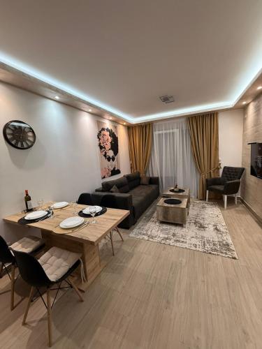 ein Wohnzimmer mit einem Tisch und einem Sofa in der Unterkunft Hil Obrenovac in Obrenovac