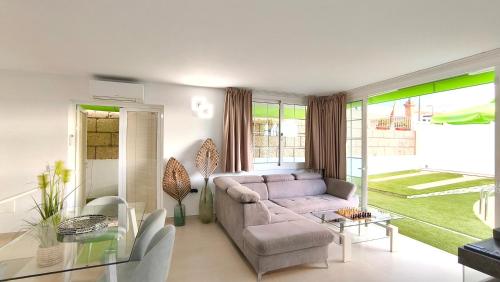a living room with a couch and a glass table at HEI HEI AND PUA VILLA - heated pool, priv parking, fibre net, Palm-Mar in Palm-Mar