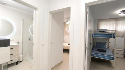a bathroom with white walls and blue bunk beds at HEI HEI AND PUA VILLA - heated pool, priv parking, fibre net, Palm-Mar in Palm-Mar