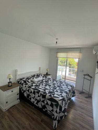 a bedroom with a bed with a black and white comforter at Hermoso apartamento en Buceo! in Montevideo