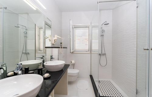 un bagno con due lavandini, una doccia e un WC di Villa None Kate by Villas Guide a Dubrovnik