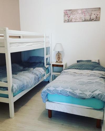 a bedroom with two bunk beds and a lamp at La Grange, gîte classé, 300m du canal & vélo-route, 2km du centre de Dole in Dole