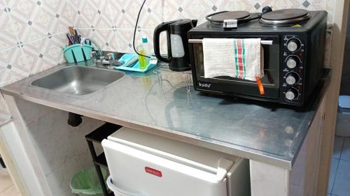 a kitchen counter with a sink and a microwave at Chayerita - Suite en La Rioja in La Rioja