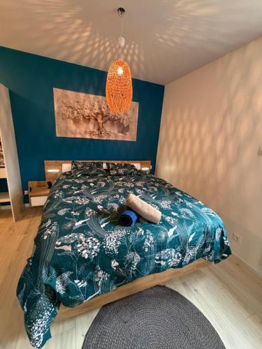 een slaapkamer met een bed en een blauwe muur bij Sauna en bord de rivière in Morez