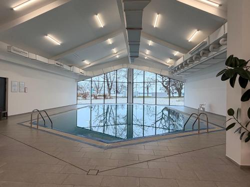 a swimming pool in a large room with a large window at A-Termal Palić in Palić
