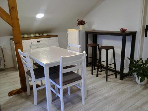 een keuken met een witte tafel en stoelen bij Riverside in Valjevo