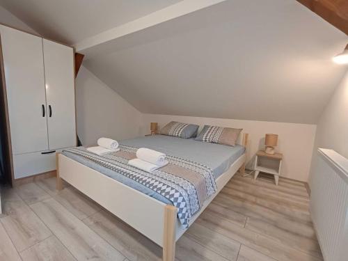 een slaapkamer met een groot bed en een witte kast bij Riverside in Valjevo