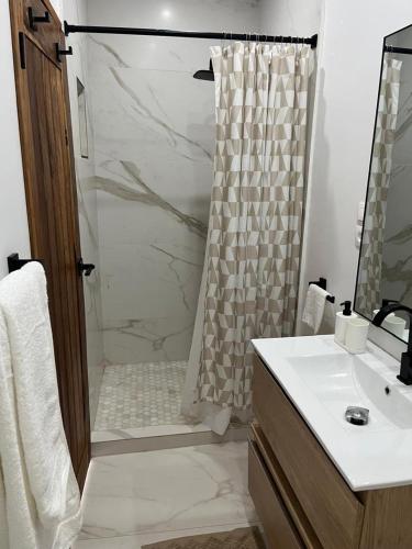 a bathroom with a shower and a sink and a toilet at Villa Regia in Poponguine