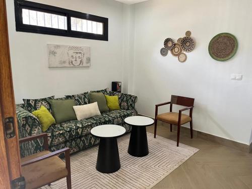 a living room with a couch and two tables at Villa Regia in Poponguine