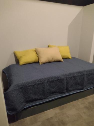 a bed with two yellow pillows on top of it at Calma Place in Carrillo