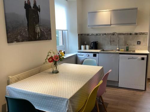 een keuken met een tafel met daarop een vaas met bloemen bij Charlies in Huntly