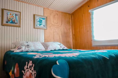 una camera da letto con un letto con una coperta blu di Cabañas del Río Bueno a Río Bueno