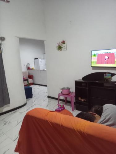 a living room with a bed and a flat screen tv at Rhanna dunas in Barreirinhas