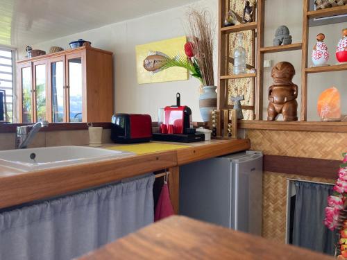 eine Küche mit Spüle und Arbeitsplatte mit Aounter in der Unterkunft Tahiti Pacific Lodge Punaauia in Punaauia