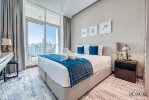 ein Schlafzimmer mit einem großen Bett und einem großen Fenster in der Unterkunft Damac Maison Prive Deluxe Studio with Water Canal View in Dubai