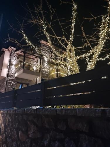 a fence in front of a building with christmas lights at Ξενώνας Αγανίππη in Livadeia