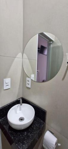a bathroom with a sink and a mirror at Hotel Triangulo Itai in Itaí