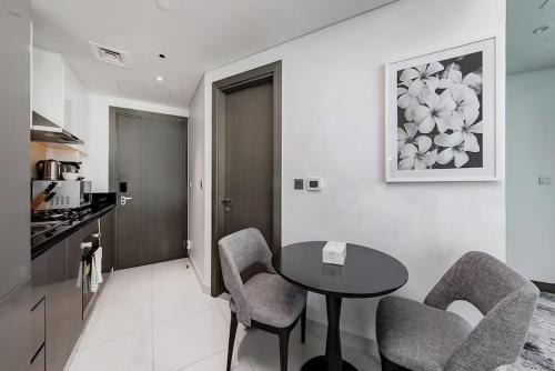 a kitchen with a table and chairs in a room at Damac Maison Prive Deluxe Studio with Water Canal View in Dubai