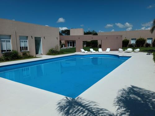 een zwembad met stoelen en een gebouw bij LS Apart Hotel in Martin Miguel de Güemes International Airport