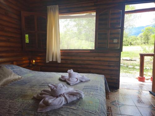 a bedroom with towels on a bed with a window at Cabañas Lumel in Carpintería