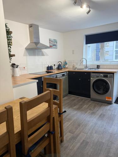 a kitchen with a sink and a dishwasher at Corner Cottage Mevagissey in Mevagissey
