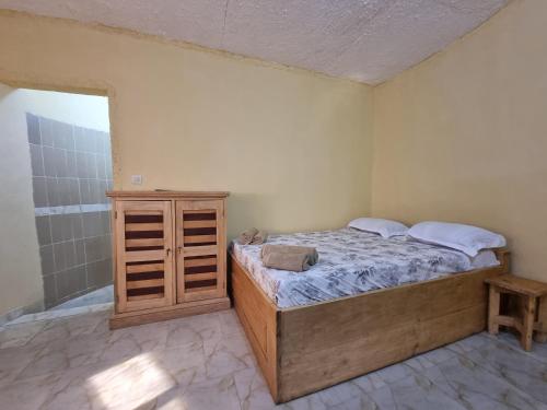 una camera da letto con un letto e un armadio in legno di BallaSte a Bignona