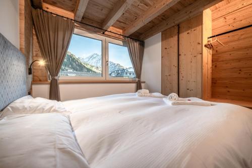 a bedroom with a large white bed with a window at - Piz Boe - Canazei center app. in Canazei