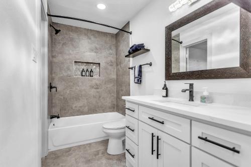 een badkamer met een wastafel, een toilet en een spiegel bij Horizon Retreat -Rockwall-Heath, TX in Rockwall