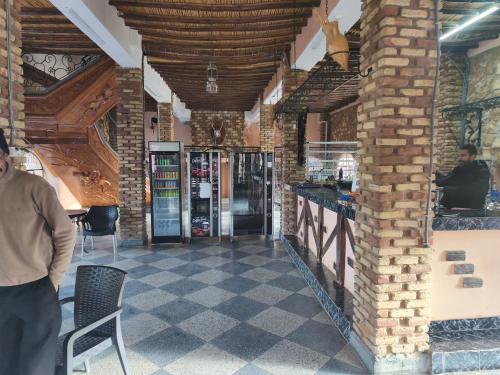 een man die voor een bar in een gebouw staat bij Hotel El Golla in Er Rachidia