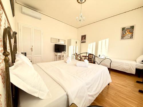 una camera da letto con due letti con lenzuola bianche di Negrar Cuore Rooms a Negrar